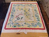Full view of the large square souvenir tablecloth depicting a Florida map with colorful details and borders.