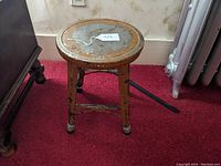 Side view of the vintage industrial steel stool highlighting its legs and paint wear.