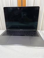 Front view of the 13 inch MacBook Pro laptop showing keyboard, trackpad, and screen with MacBook Pro branding.