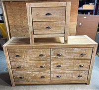 Front view of distressed wood dresser with six drawers, dark metal cup pull handles, and a matching nightstand on top.