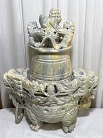 Front view of stone incense burner with dragon carvings and lion figurine on lid