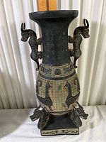 Front view of the ornate dragon themed composite vase with dragon handles and Chinese inscriptions
