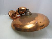 Copper metal dome side view of vintage mid-century modern ceiling light with pull-down mechanism.