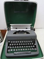 Front view of Royal manual typewriter in open original hard case with green felt lining.