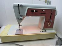 Front and side view of the vintage SINGER sewing machine showing base case with yellow discoloration and front panel controls.