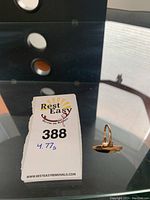Photo of ring next to auction tag showing weight 4.77 grams