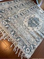 Overview of stacked area rugs showing pattern and fringes