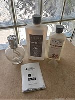 Image showing the clear glass Lampe Berger aroma lamp, the large Maison Berger Lampe refill bottle, the smaller Aroma Relax scented refill bottle, and the instruction manual.