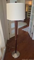 Full height view of floor lamp showing shade, wood column and metal base