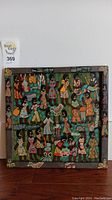 Full view of the 13x13 inch square African painted wood art with multiple colorful figures in traditional attire on a dark background with floral border.