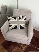 Front view of grey armchair with Union Jack pillow placed on seat