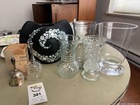 Overview photo showing all items together on table: mother of pearl vase, various glass vases, silver plated bell, crystal bell with silver plate handle.