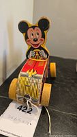 Front view of vintage wooden Mickey Mouse toy car, showing Mickey figure, grill, and wheels.