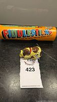 Photo of the Fiddlesticks game container and the wind-up dog toy with auction lot tag.