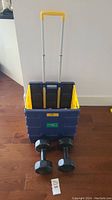 Foldable Pack and Roll utility cart with telescoping handle and pair of dumbbell weights in front