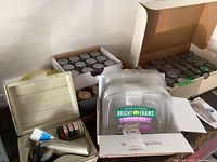 Open boxes and containers showing clear plastic storage containers and a beige Dymo label maker along with label rolls.