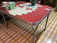 Full view of mid century style rectangular table with chrome legs and formica top. Visible scratches and some rust on legs.