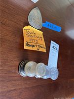 Photo shows the Towle sterling silver pendant and two Newport sterling silver shakers on a wooden surface, with handwritten notes.