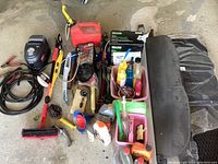 Overview of items including Craftsman air compressor, jumper cables, cleaning liquids, Subaru Forester floor mats, assorted bungee cords and tools.