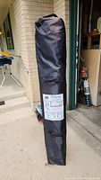 Black carrying bag for EZUp Instant Shelter with visible label showing setup and takedown instructions.