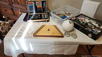 Music maker autoharp with music sheets, markers, quilling paper, and glass case visible on table