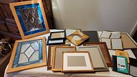 Overview of stained glass pictures with cactus and butterfly designs alongside a variety of empty picture frames