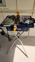 Full view of Ryobi tile saw on metal foldable stand with power cord visible, showing the overall item and setup.