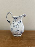 Front angled view of the milk jug showing body shape and decorative pattern