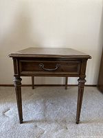 Front view of the Henredon solid wood side table showing the drawer and carved tapered legs