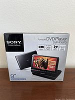 Front view of the box showing model Sony DVP-FX970 portable DVD player with 9-inch widescreen LCD.