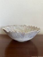 Side profile view showing the scalloped edge and embossed shell rim with iridescent glaze.