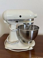 Side view of the mixer showing Hobart label, power cord and attachments in bowl.