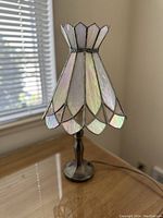 Clear view of the lamp showing the iridescent stained glass shade with petal shapes and metal base.