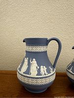 Single blue jasperware Wedgewood pitcher with white classical relief decoration showing Etruscan figures and floral bands