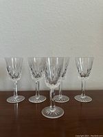 Four vintage Waterford crystal glasses showing full items with cut patterns and starburst bases