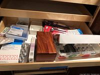 Drawer with various baking accessories, piping tips, and a wooden box