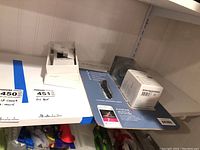 Shelf setup showing Fitbit Charge HR product boxes and earbuds packaging grouped together with labeled lot numbers.