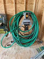 Front view of Rockwell Jawhorse with green and black hoses coiled around