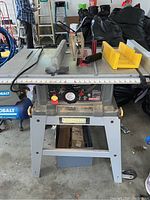 Front view of Craftsman table saw on a metal stand with blade guard and measuring scale on table