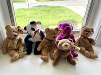 Six Ty Beanie Babies bears sitting on a window ledge, showing full group and tag placement
