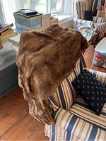 Brown fur piece draped over chair showing plush fur and rich color
