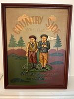Full view of the framed wooden relief sign showing two vintage golfers, background golf course and text.