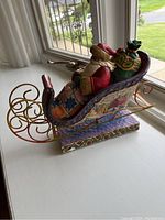 Side view of Santa Claus in the sleigh showing detailed carving and painted village scenes