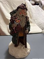 Full view of the Santa Claus figurine showcasing detailed painting and snow base.