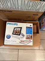 Philips digital photo frame in original box, shown on tile floor.