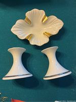 Top view of the leaf-shaped white ceramic tray with gold accents and two white candle holders with gold trim.