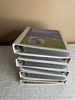 Stack of five white three-ring binders filled with baseball cards and labeled on spine.