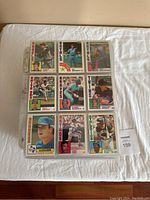 1984 Topps baseball cards displayed in 9-card plastic sleeves showing players from various MLB teams.