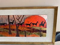 Full view of framed enamel on copper artwork showing black horse silhouettes, trees, and a large orange sun with abstract landscape in copper tones.