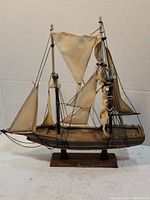 Side view of the Bluenose ship model showing full sails, rigging, and wooden base with plaque.